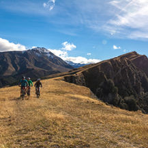 Three people mountain biking on a hill in Queenstown New Zealand