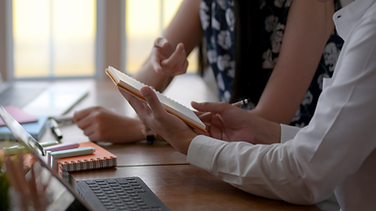 People working at a desk reviewing discussing documents