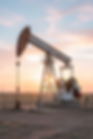 Oil pumpjack operating at sunset in a flat West Texas landscape