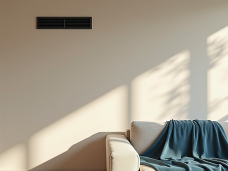 Living room interior with a wall air vent and natural sunlight, representing proper HVAC airflow after a well-installed system