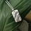 Thumbnail: Handmade Silver Summer Meadow Necklace on a leaf