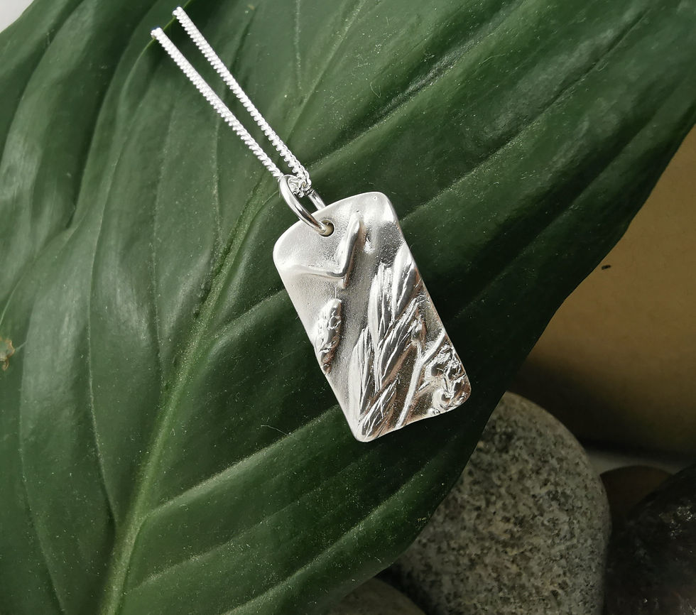 Handmade Silver Summer Meadow Necklace on a leaf