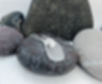 white Celtic shell sea glass necklace on a pebble