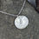 Thumbnail: silver leaf circle necklace on a pebble