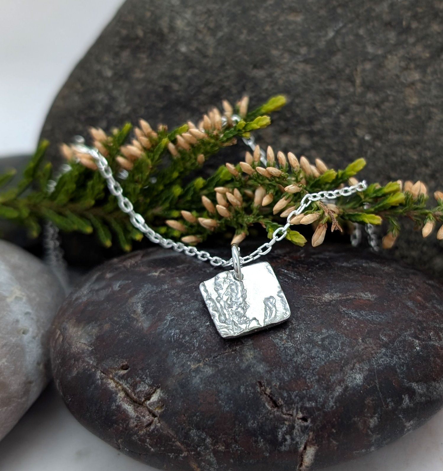 Square Scottish heather necklace on a pebble