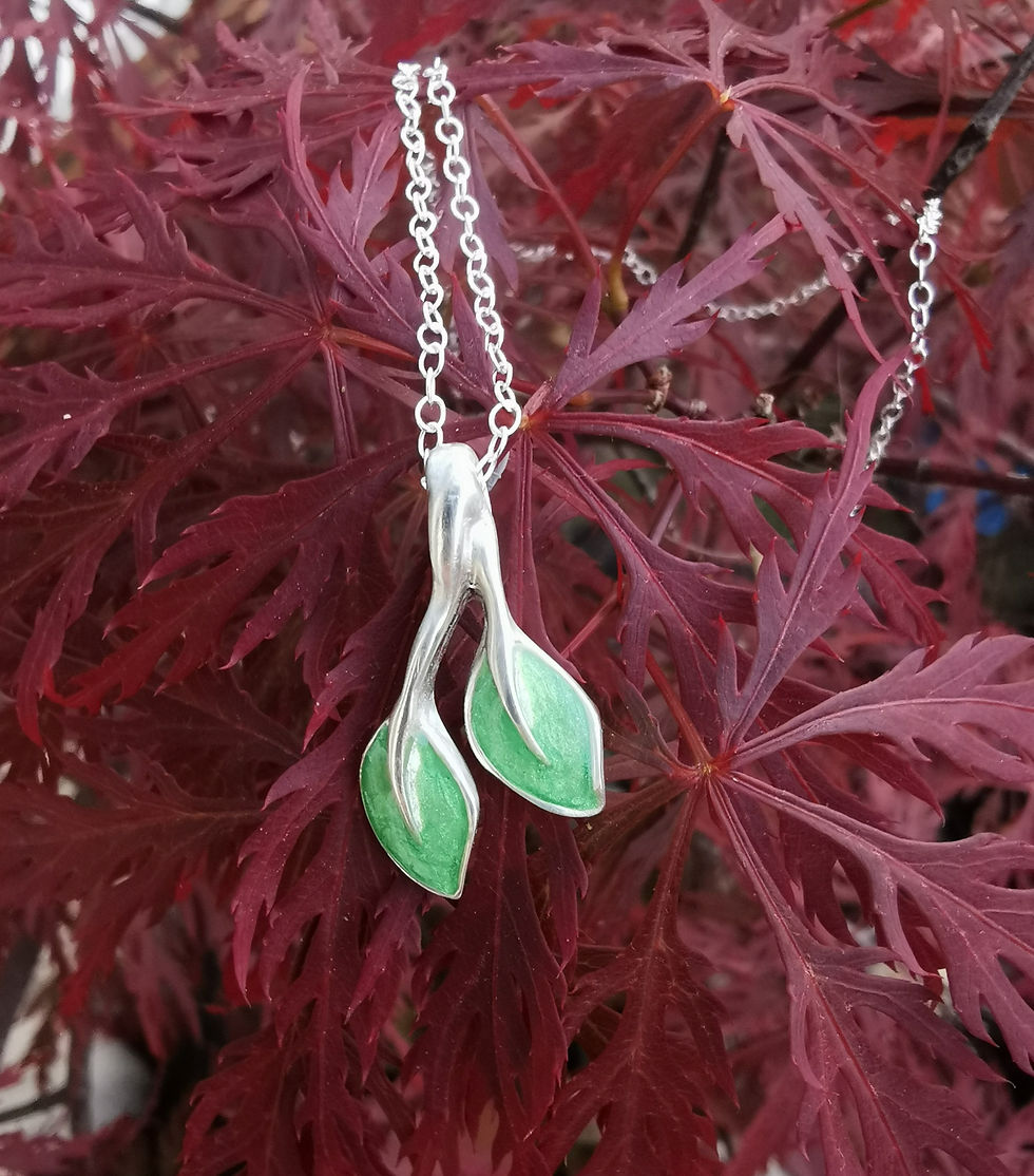 Silver and Green Spring Leaf Necklace on a tree
