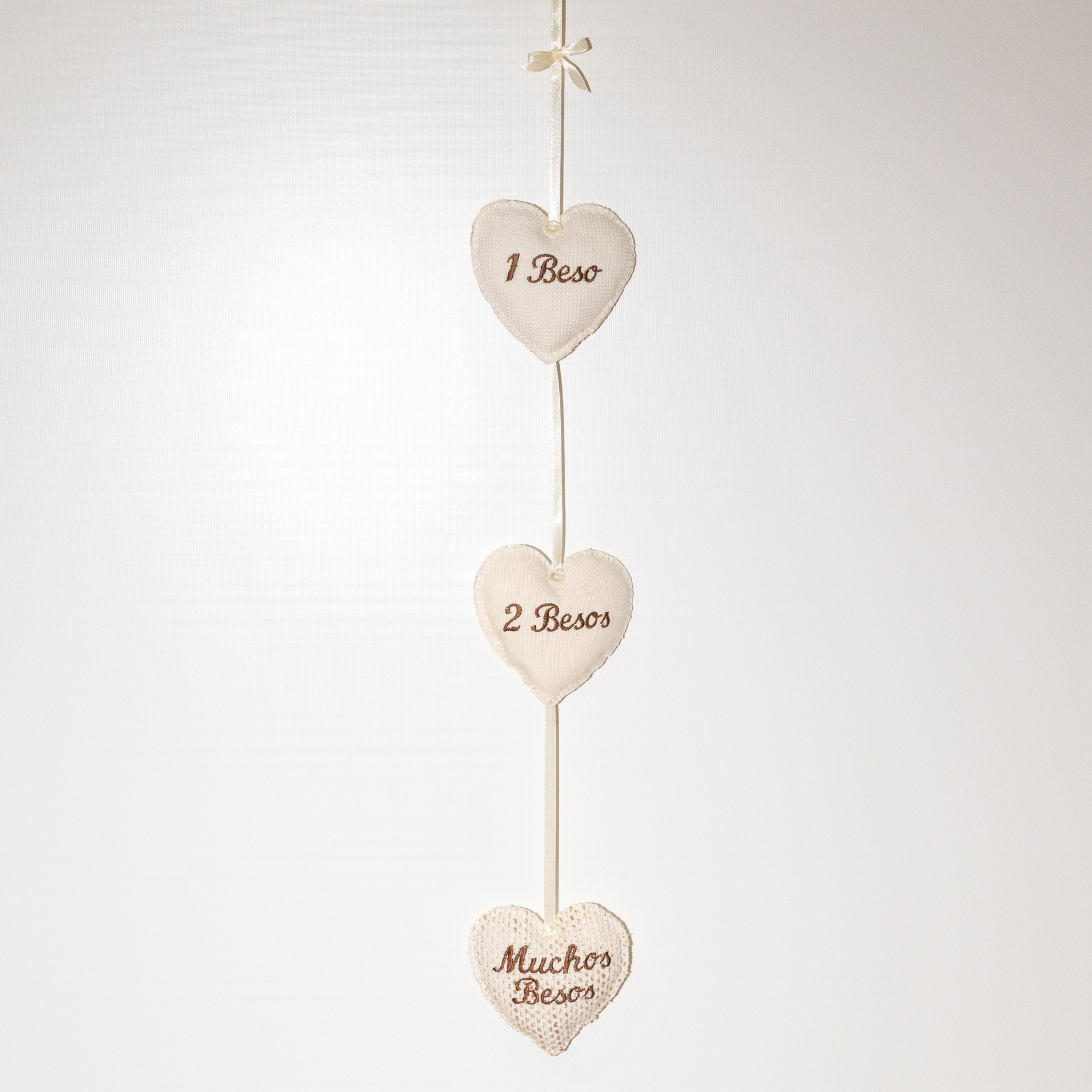 "Colgante artesanal de corazones en tonos beige"