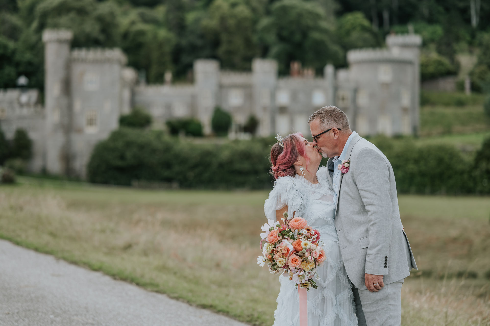 Couple embrace in front of caerhays castle 