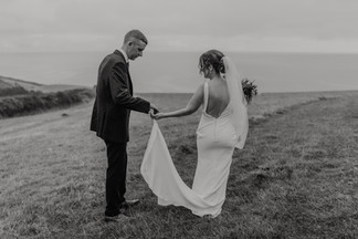 wedding couple walking along the cliffs overlooking Lanivet Bay