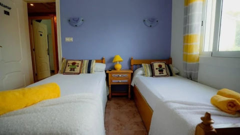 a bedroom with two full beds, with a nightstand in between them