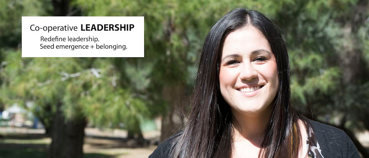 A young woman with long dark hair smiles at the camera.