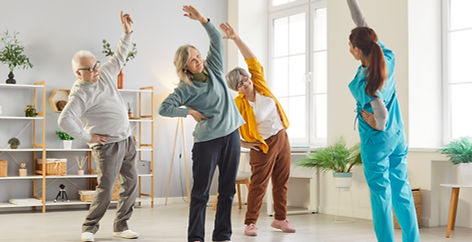 Groupe de personnes âgées faisant des exercices guidés par un physiothérapeute à domicile de Physio à la Maison.