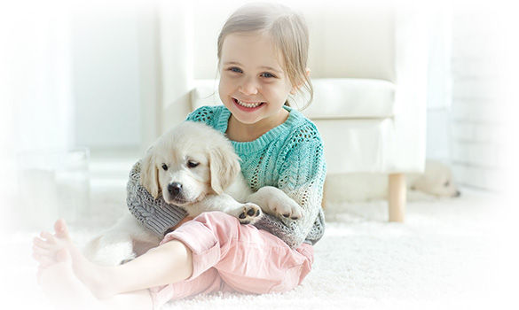 a little girl holding a dog