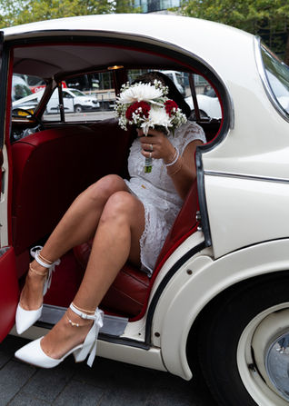 Bride stepping out of a vintage wedding car provided by Lucky Penny Wedding outside Old Marylebone Town Hall