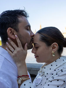 Close-up of bride’s hand on groom’s face highlighting new engagement ring in a romantic engagement photoshoot moment
