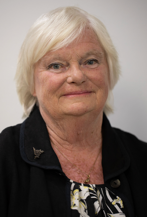 Smiling woman with white hair, a team member