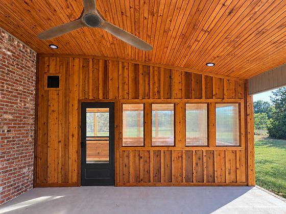 Wood-lined porch with a ceiling fan, windows and detailed trim.