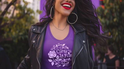 Smiling woman wearing purple "Como La Flor" shirt