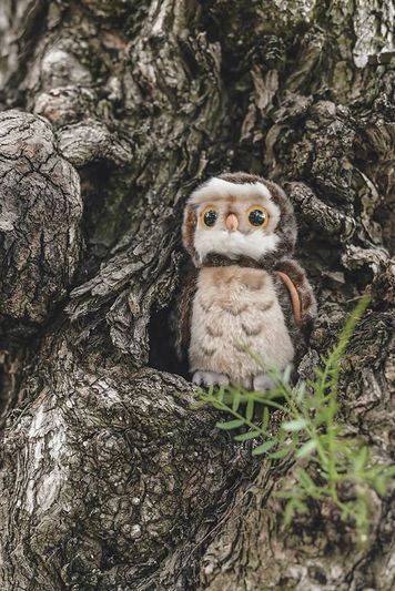 Adorable owl plush toy nestled in tree