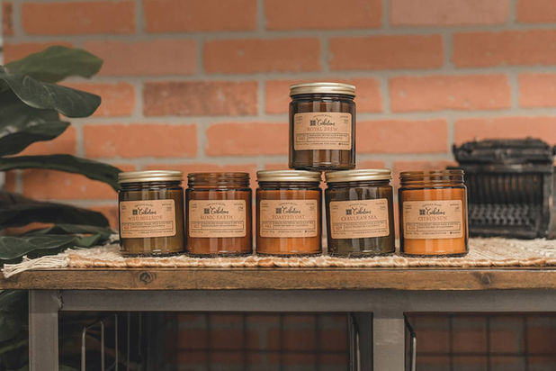 Six amber glass candles, various scents