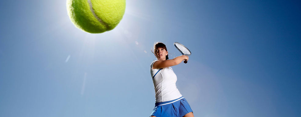 Tennis player swinging a racket to hit a ball during a match.