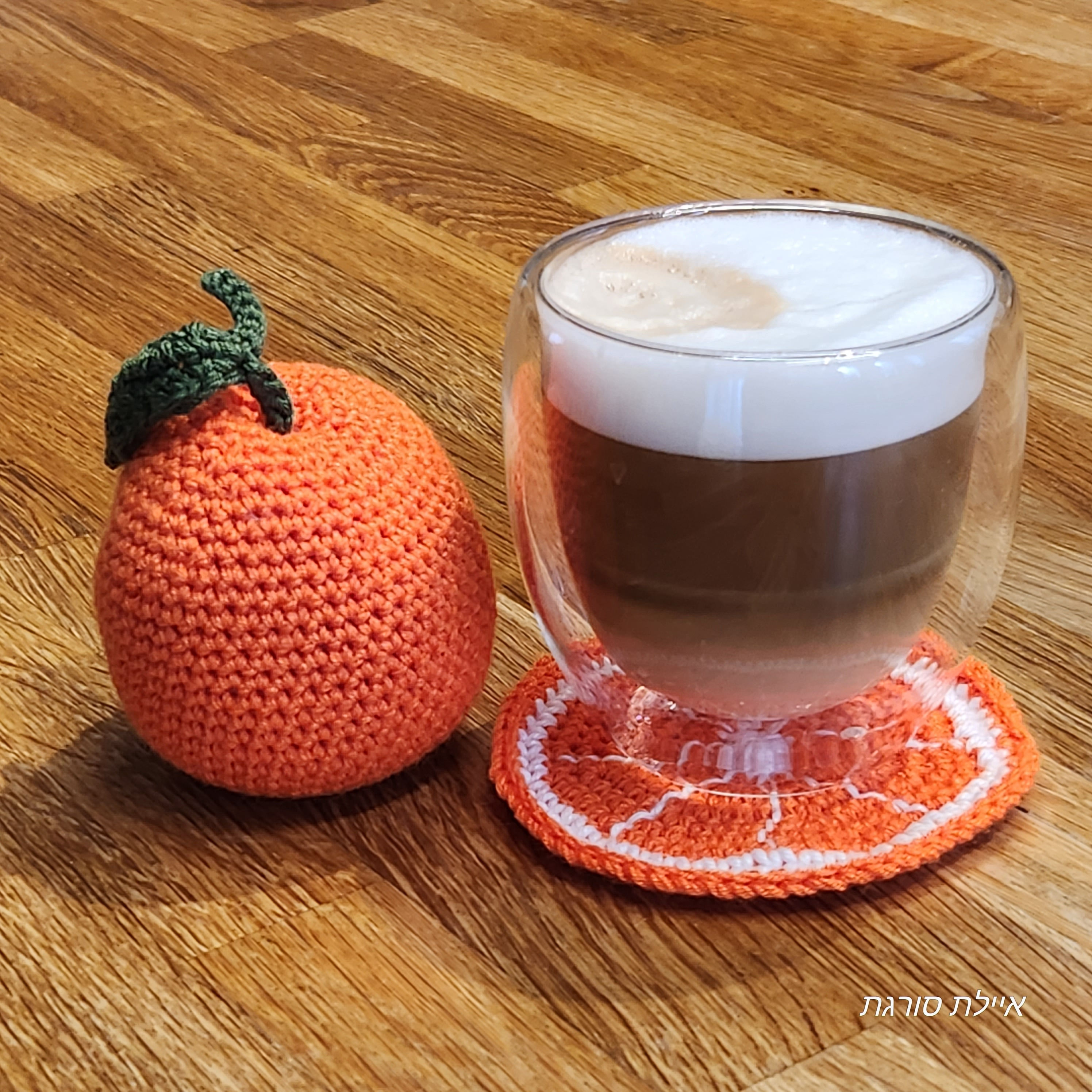 An Orange and the bottom of an orange segment are hand-knitted Amigurumi Orange