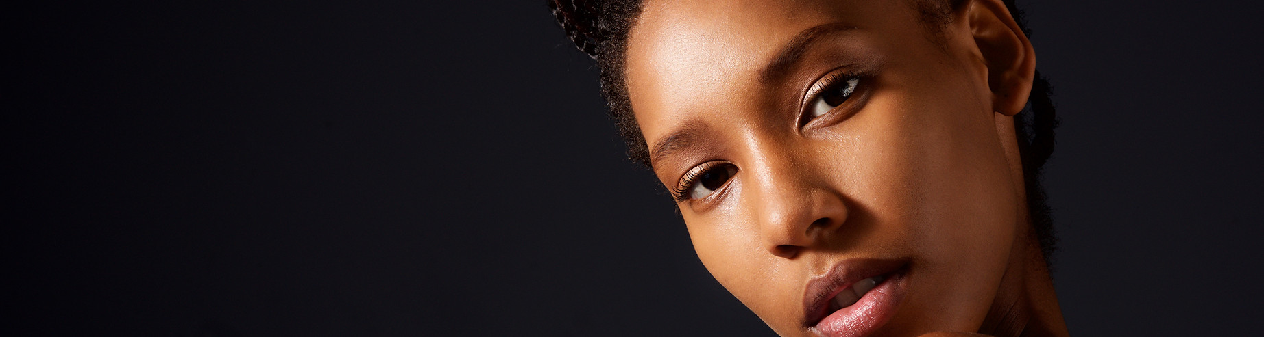 close up of a black woman's face with hand on her face