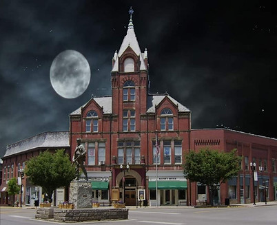 Twin City Opera House in McConnelsville, Ohio, lit by a large full moon, creating a spooky, historic atmosphere.