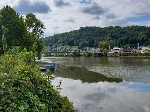 Scenic view of the Muskingum River in McConnelsville, Ohio, with calm water and tree-lined banks.