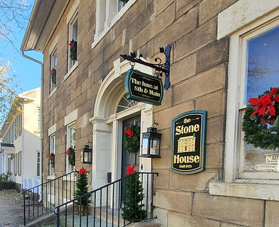The historic Stone House at The Inns at 8th & Main decorated for Christmas with lights, greenery, and holiday charm in McConnelsville, Ohio.