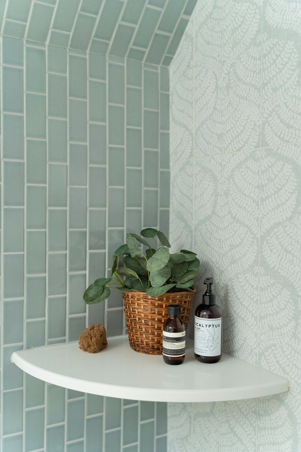 Shower with vertically stacked grey subway tile and Annie Selke botanical tile