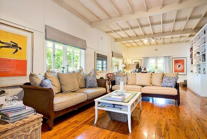 relaxed living room in Australian beach house with floorboards, built in bookcase and high ceilings
