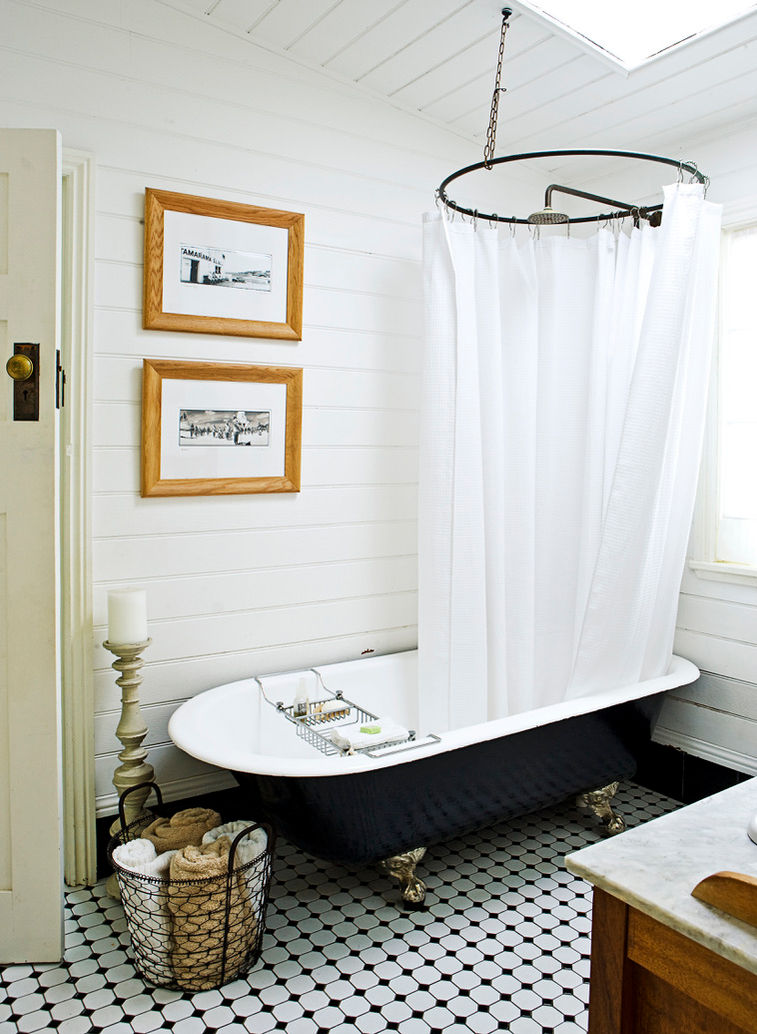sun-filled beach house bathroom with mosaic tile floor and claw foot tub