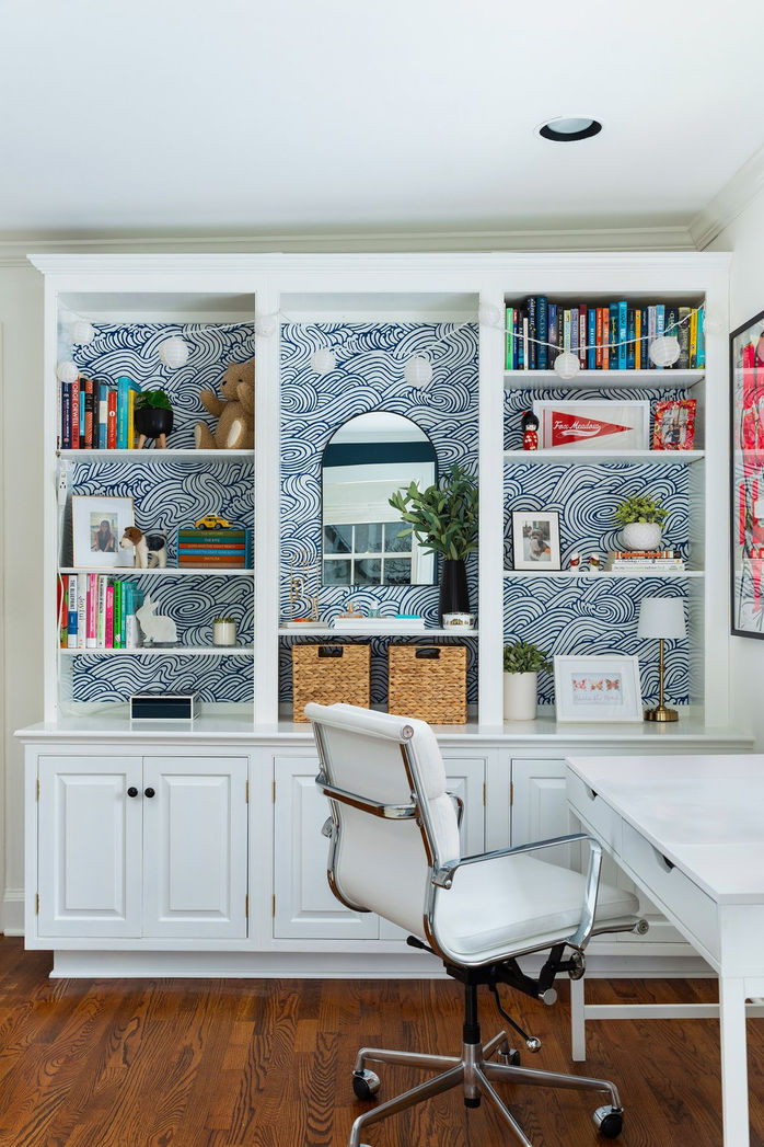 Teenage girls bedroom with white bookcase and blue wallpaper
