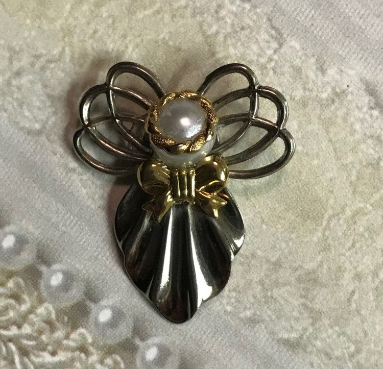 Thumbnail: One decorative angel-shaped brooch, in silver, featuring pearl accents and bow details.