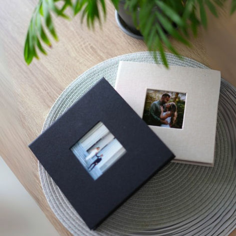 Minimal wedding guestbook albums in black and beige on table.
