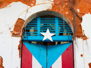 Puerta antigua pintada con la bandera de Puerto Rico, símbolo de memoria cultural, identidad caribeña y soberanía frente a las infraestructuras tecnológicas.