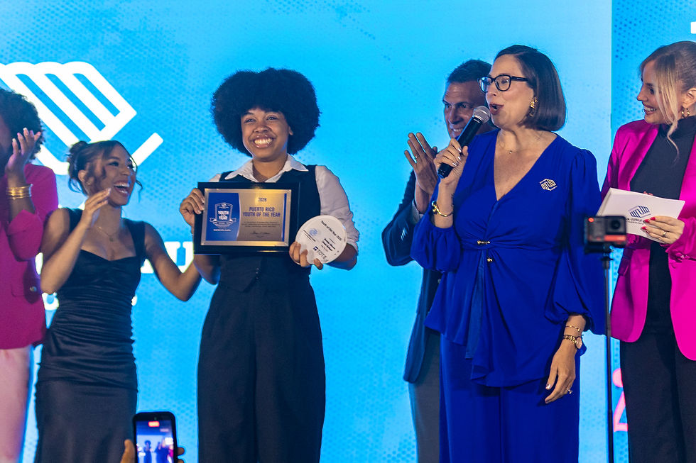 Yenzielys A. Estrada, Joven del Año 2026 de Boys & Girls Clubs de Puerto Rico, sostiene su placa de reconocimiento en tarima durante la ceremonia celebrada en Dave & Buster's de Plaza Las Américas.