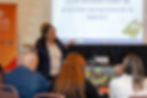Facilitadora del programa Aprendo de United Way presenta ante participantes durante su taller práctico en el Día de la Iniciativa Preescolar de la Fundación Ángel Ramos. Al fondo, la proyección con la pregunta: "¿Qué conozco sobre las prácticas apropiadas de la NAEYC?"