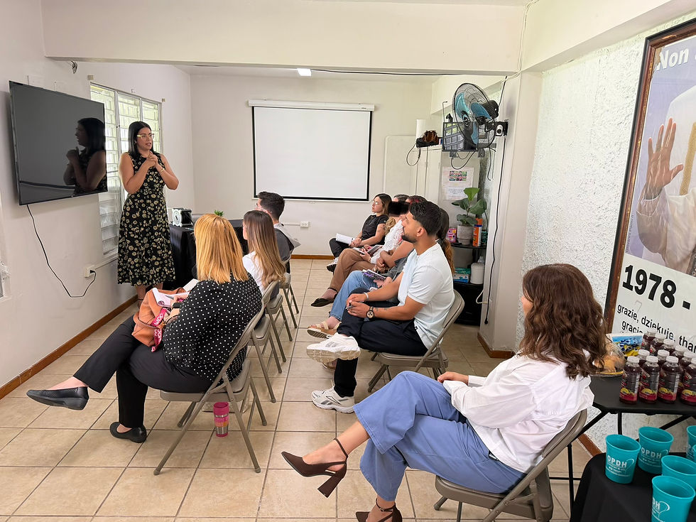 Una mujer ofrece una presentación ante un grupo de personas en un salón de la Oficina para la Promoción y el Desarrollo Humano.