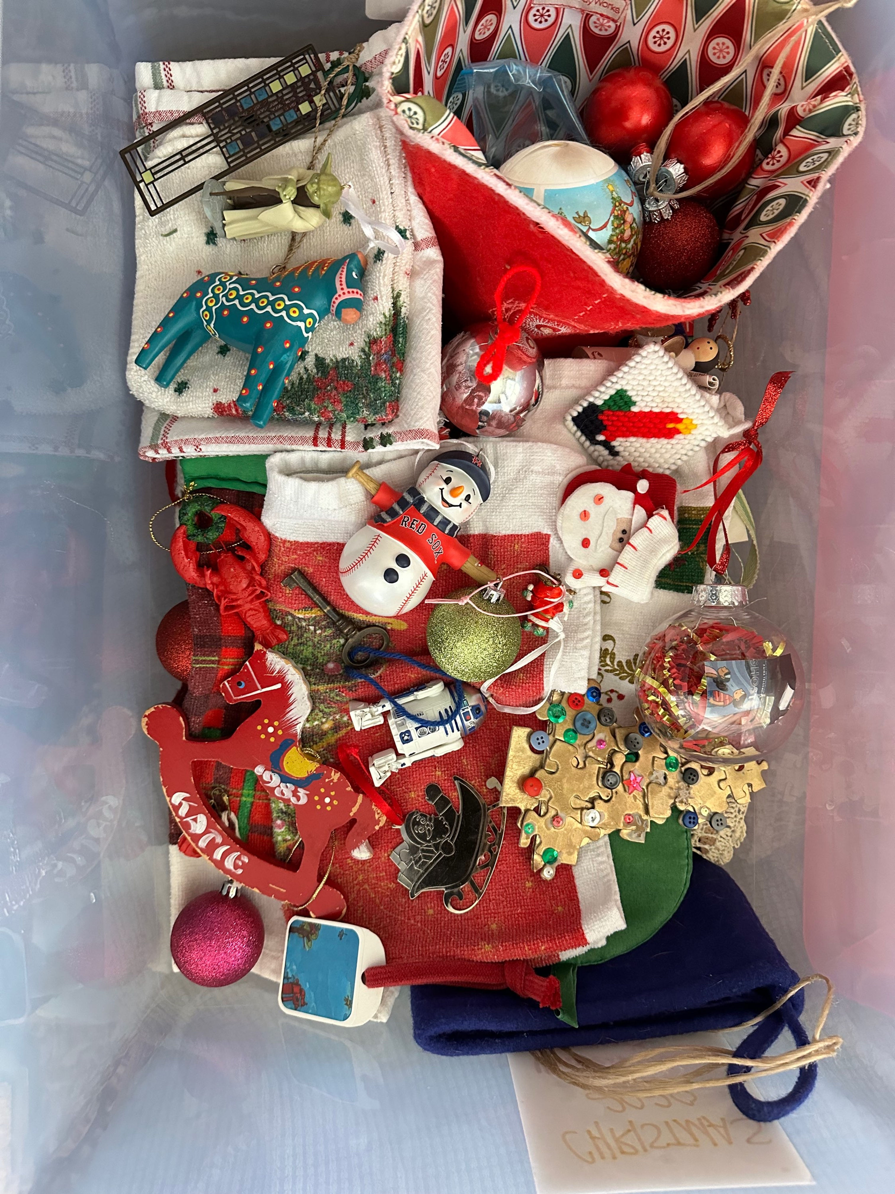 Birds-eye view of a box of various Christmas ornaments.