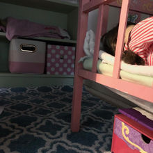 The finished underside of the loft bed, lined with open bins. 