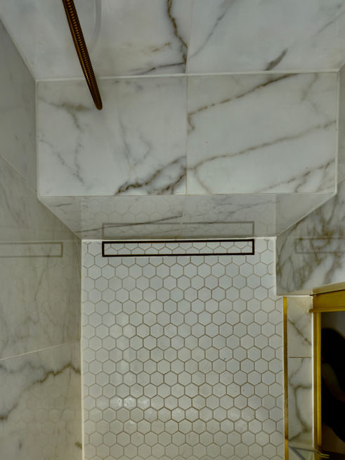Modern shower room with textured tiles, built-in shower bench and brass fittings