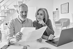 middle-aged-couple-reading-paper-bills-calculating-2021-09-02-15-11-20-utc.jpg