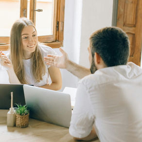 A couple sitting by their computers talking