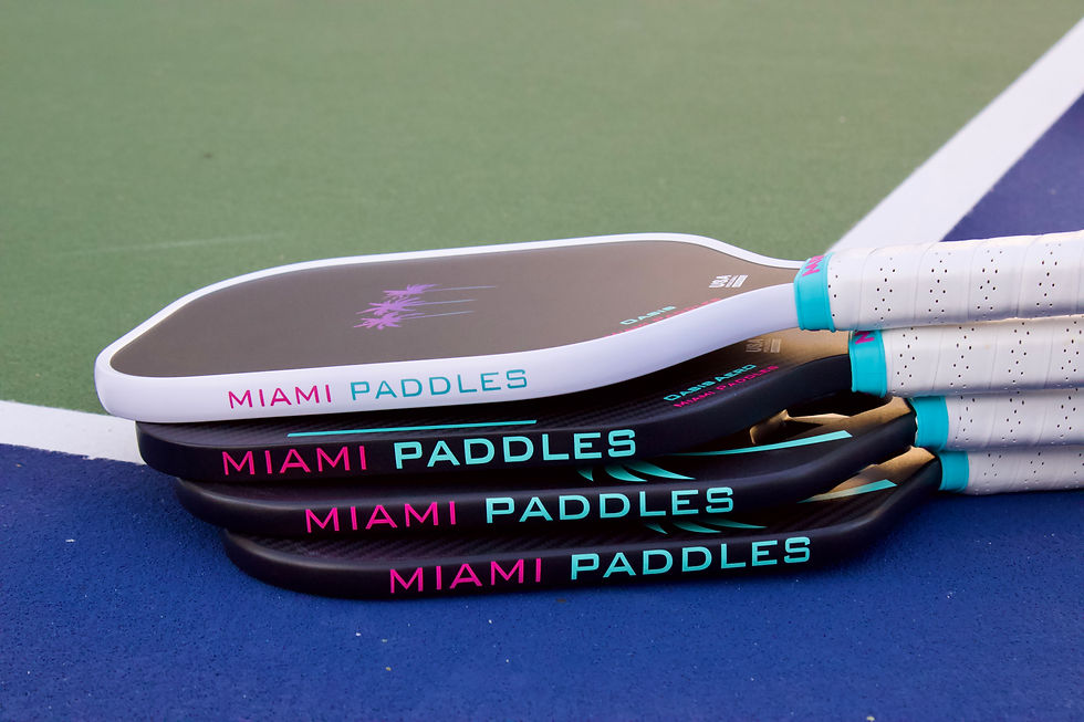 Thumbnail: Stacked Miami Paddles pickleball paddles on a blue court surface with white boundary lines.