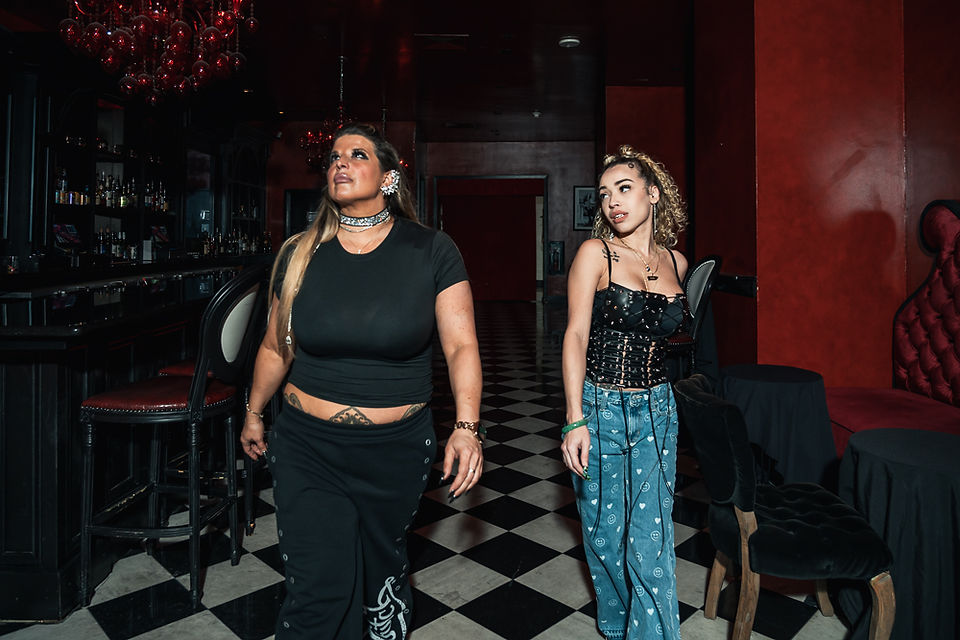 Two women celebrating a birthday with portraits inside Burgundy Bar New Orleans