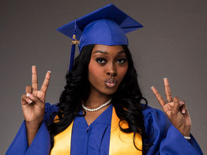Holmes Healthcare Training Center graduate wearing a purple cap and gown with a gold sash at New Orleans East Hospital