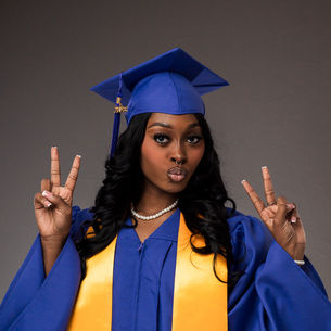 Holmes Healthcare Training Center graduate wearing a purple cap and gown with a gold sash at New Orleans East Hospital