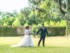 groom leading bride across a field